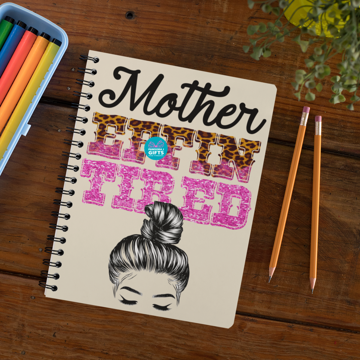Wired notebook with the words "Mother Effin Tired" and a drawing of a mom with a high bun.