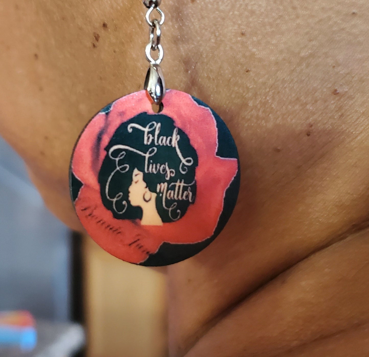 1/2 Inch Custom Earring. Pictured is Black earring with a Woman with a large beautiful afro with the words "Black Lives Matter" inside.